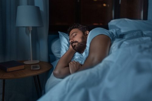 indian man sleeping in bed at home at night