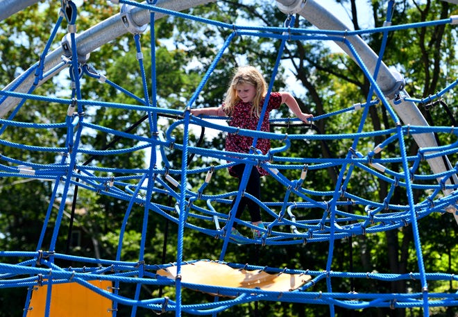 Ellie Lavigne, 6, of Worcester reached the top of the large climbing structure at the new Coal Mine Brook Park on Plantation Street Monday.