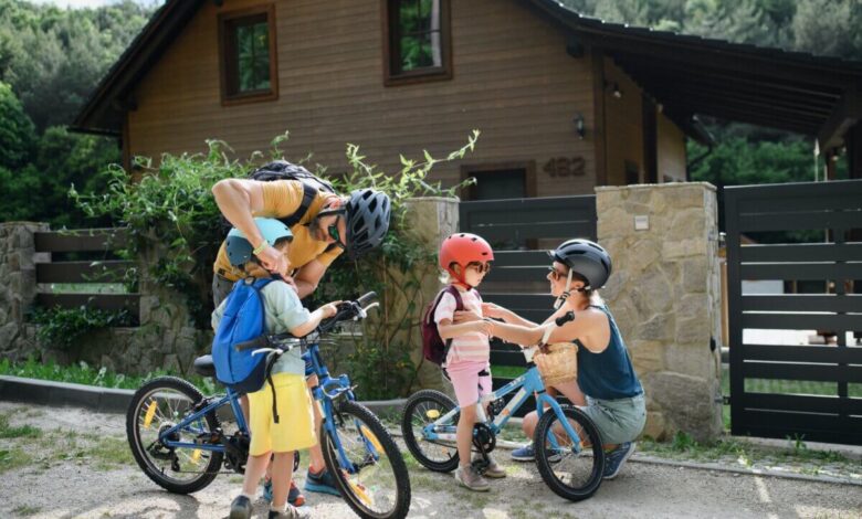 Parents putting bike helmets on their children
