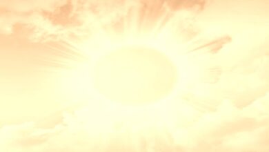 A blazing yellow sun with sun rays against a yellow-red background with clouds; concept is heat-related illness