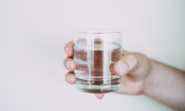 A person holding a small cup of water