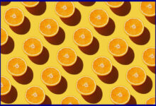 A number of cut oranges against a yellow background.